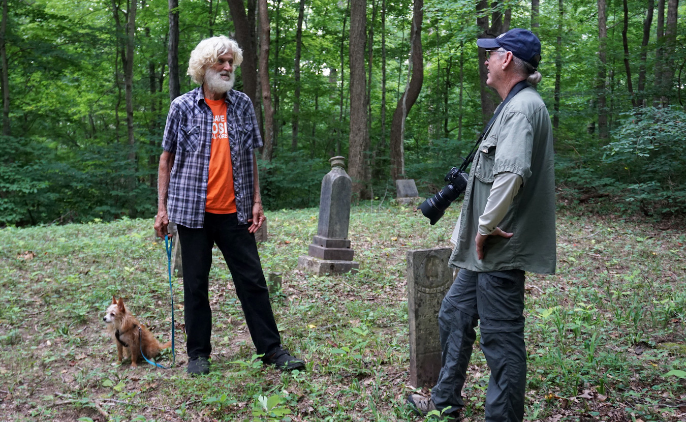 Andy Mahler, left, and author and photographer Steve Higgs share stories in a pioneer cemetery in the middle of the Hoosier National Forest. | Photo by Anne Kibbler