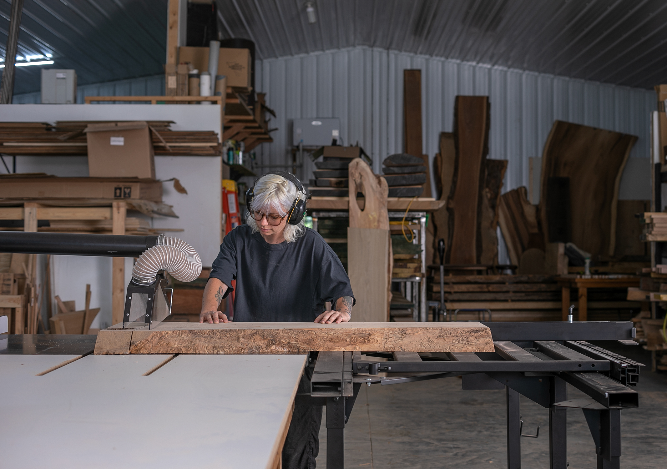 Ivy Siosi operates a table saw in her woodshop.