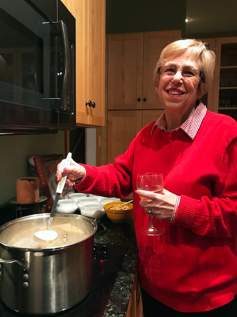 Bobbie Weinberg poses with a soup ladle and a wine glass.