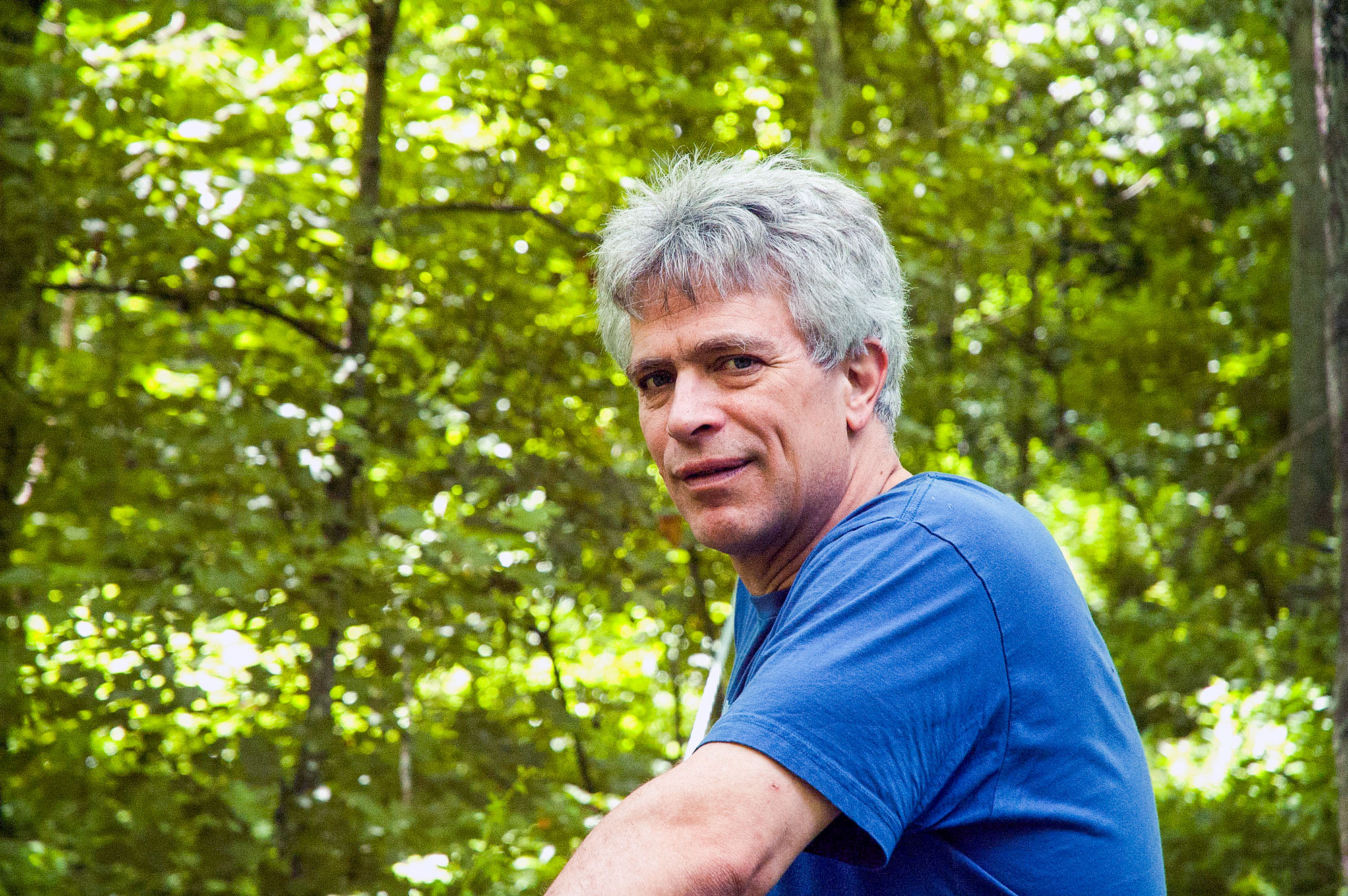 Jeff Stant, man with grey hair wearing blue t-shirt in the forest.
