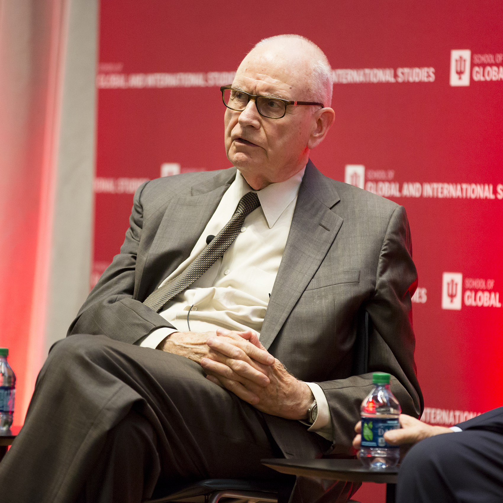 Lee Hamilton sits before a red backdrop