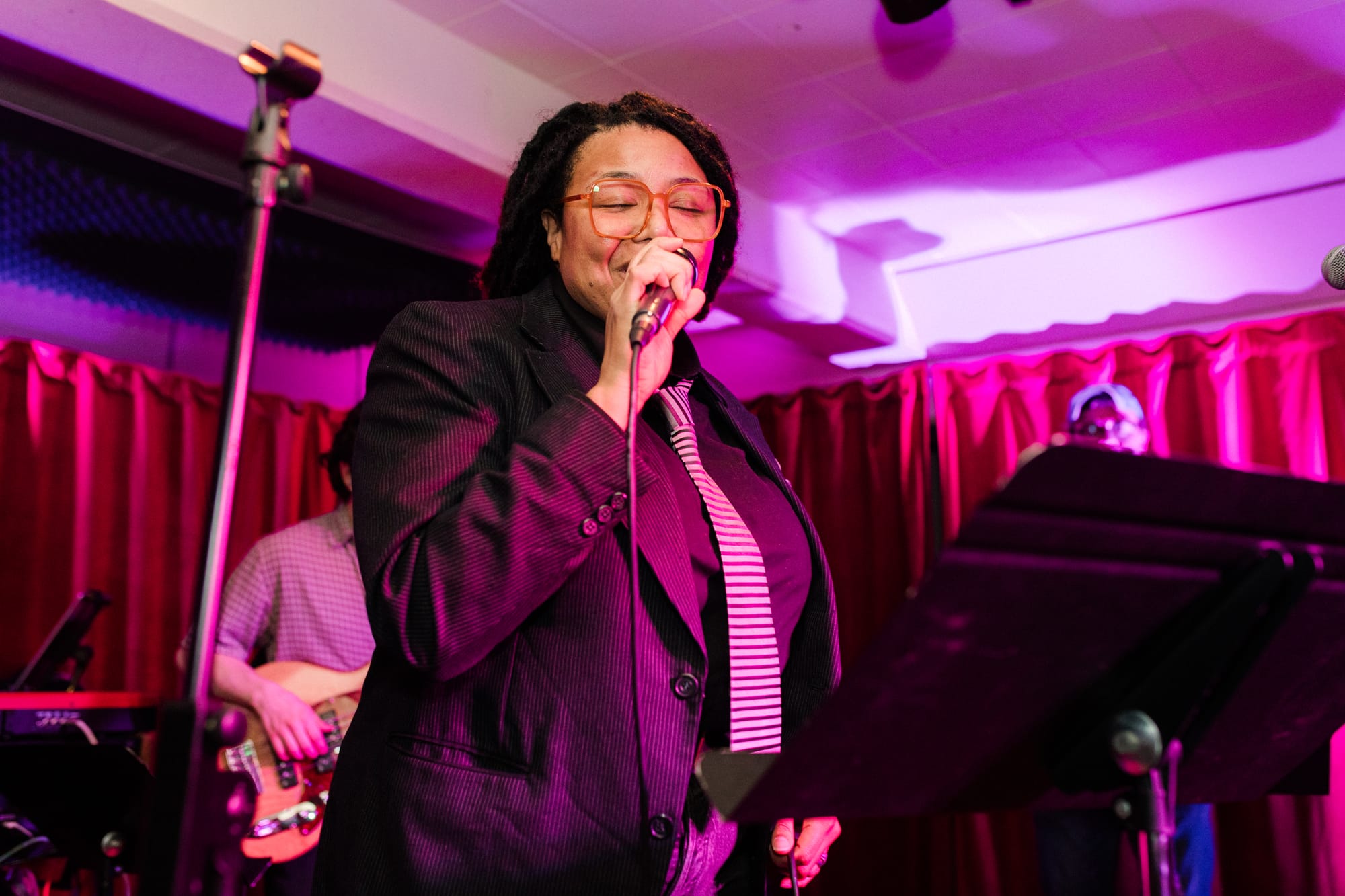 Andrea "De" de la Rosa holds a microphone on the Blockhouse stage.