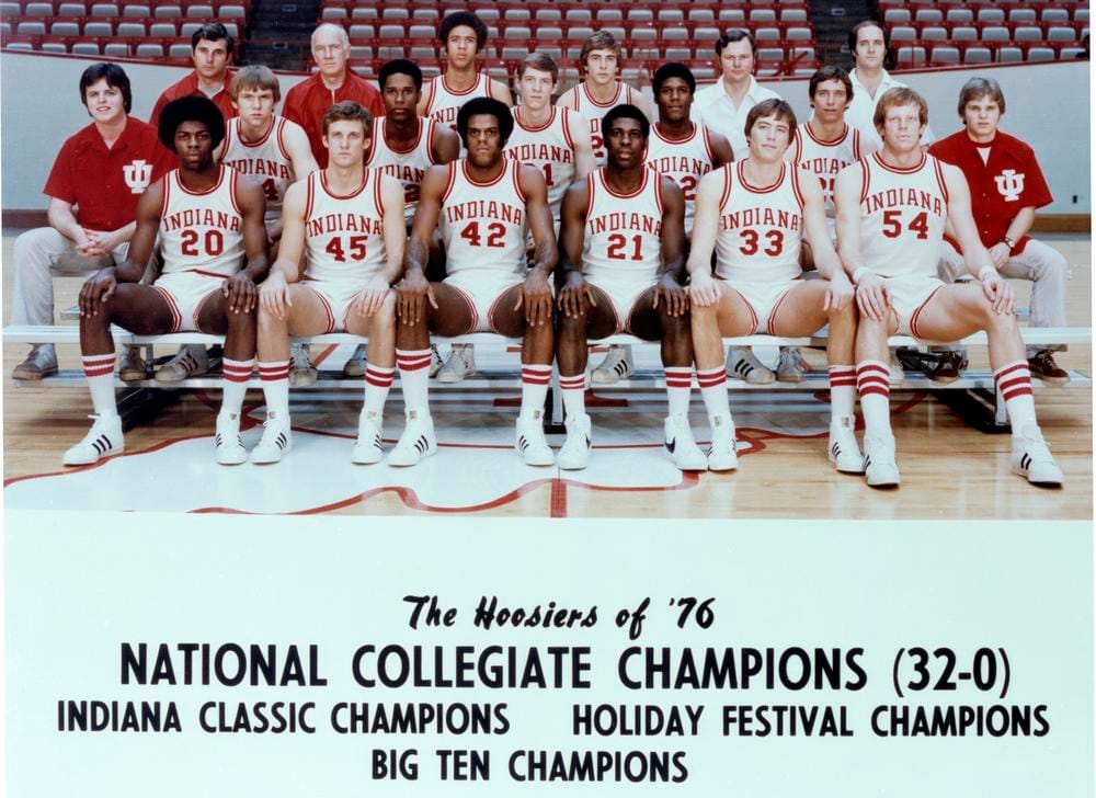 A color photograph from 1976 shows the Hoosier basketball team with coaches and assistants sitting on bleachers in Assembly Hall