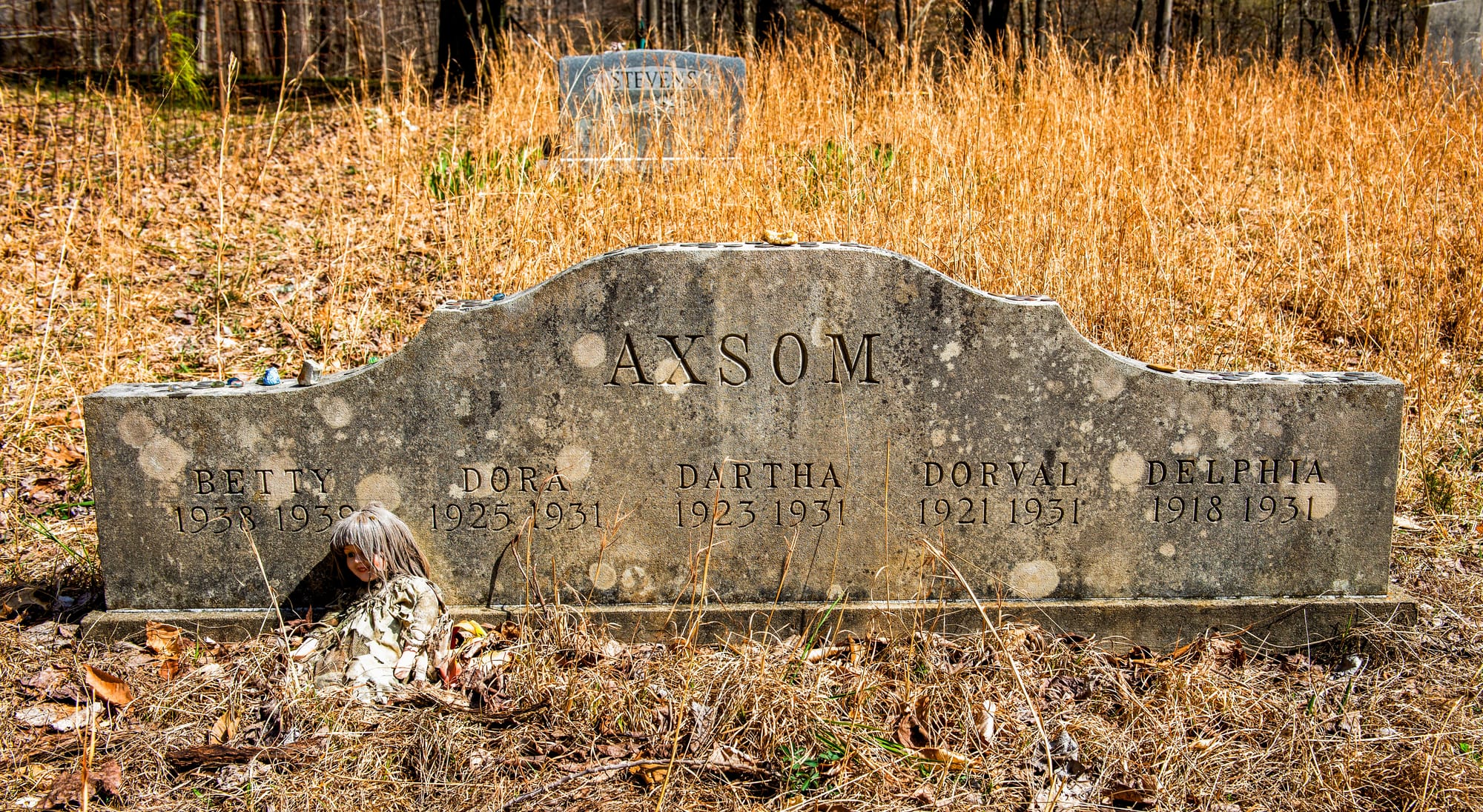 A gravestone from the 1930s listing the names of five deceased young girls — Betty, Dora, Dartha, Dorval, and Delphia Axsom