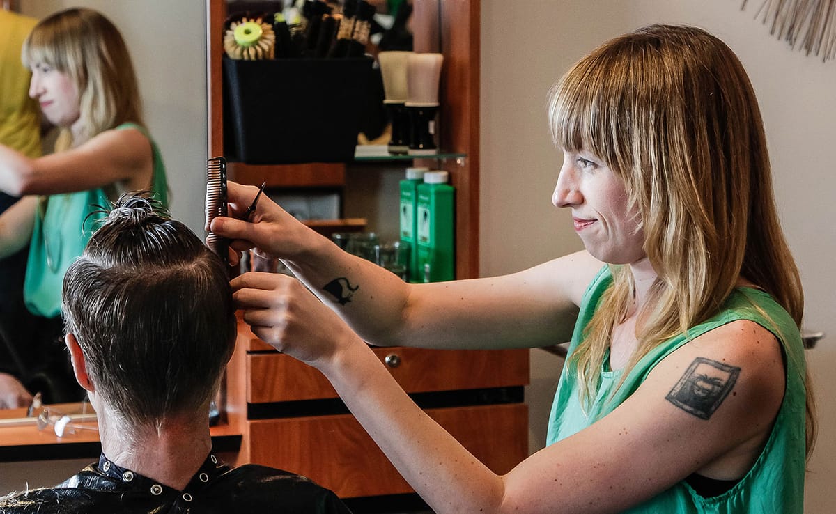 Cathleen Paquet, a hairstylist at Hairstream Studio, styles a client's hair. She says this trade allows her "to connect with