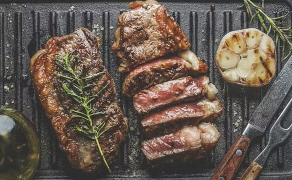 steak and garlic on griddle