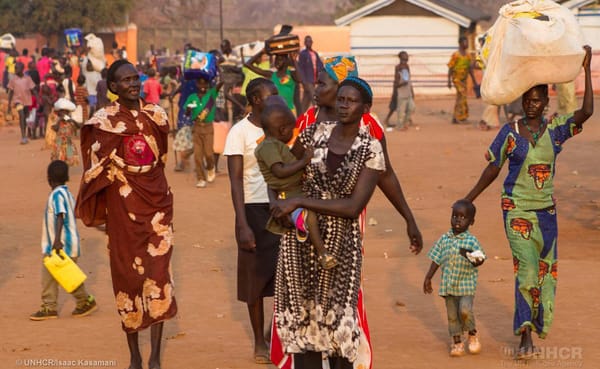 Newly arrived South Sudanese refugees carry their belongings at the Nyumanzi reception center in the northern district of Uga
