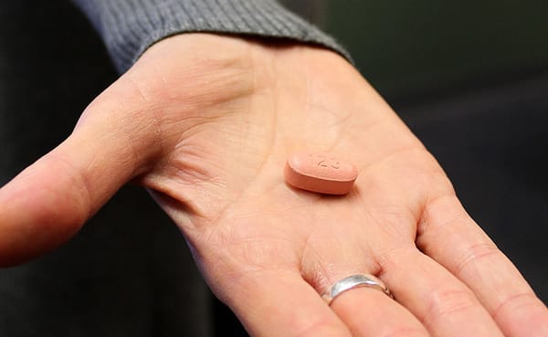 Lead Care Coordinator for Client Services at Positive Link, Tammy Baynes, holds an HIV antiviral drug called Atripla. While t