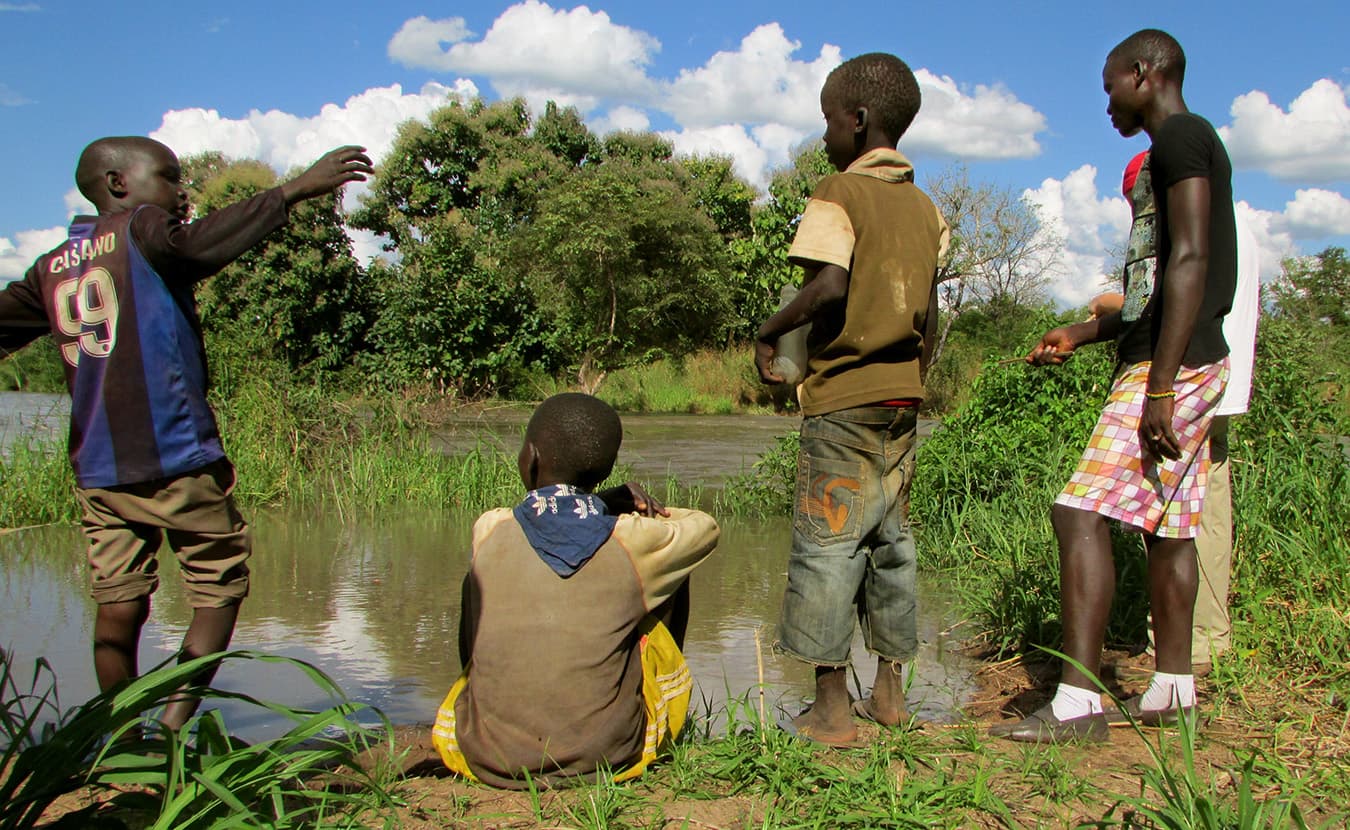 Moru youth fishing at a river behind Will and Theresa's house. | Photo by Will and Theresa Reed