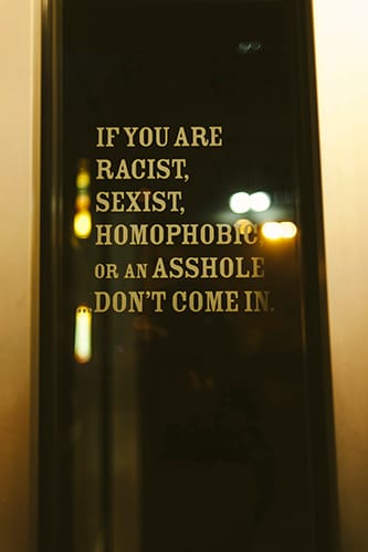 All three bar managers strive to cultivate an environment that isn’t conducive to aggressive behavior. This sign greets patrons of Atlas at the door. | Photo by Natasha Komoda