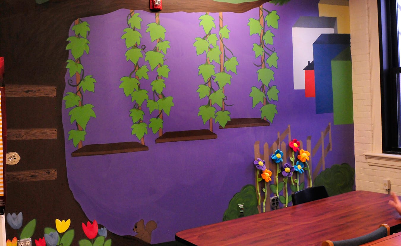 The mentors created a "transitions wall" to provide a visual diagram to track the progress of each incarcerated youth, with each part of the mural depicting a different step in their progress. Each youth writes her name as she moves through the steps. | Photo by Ann Georgescu