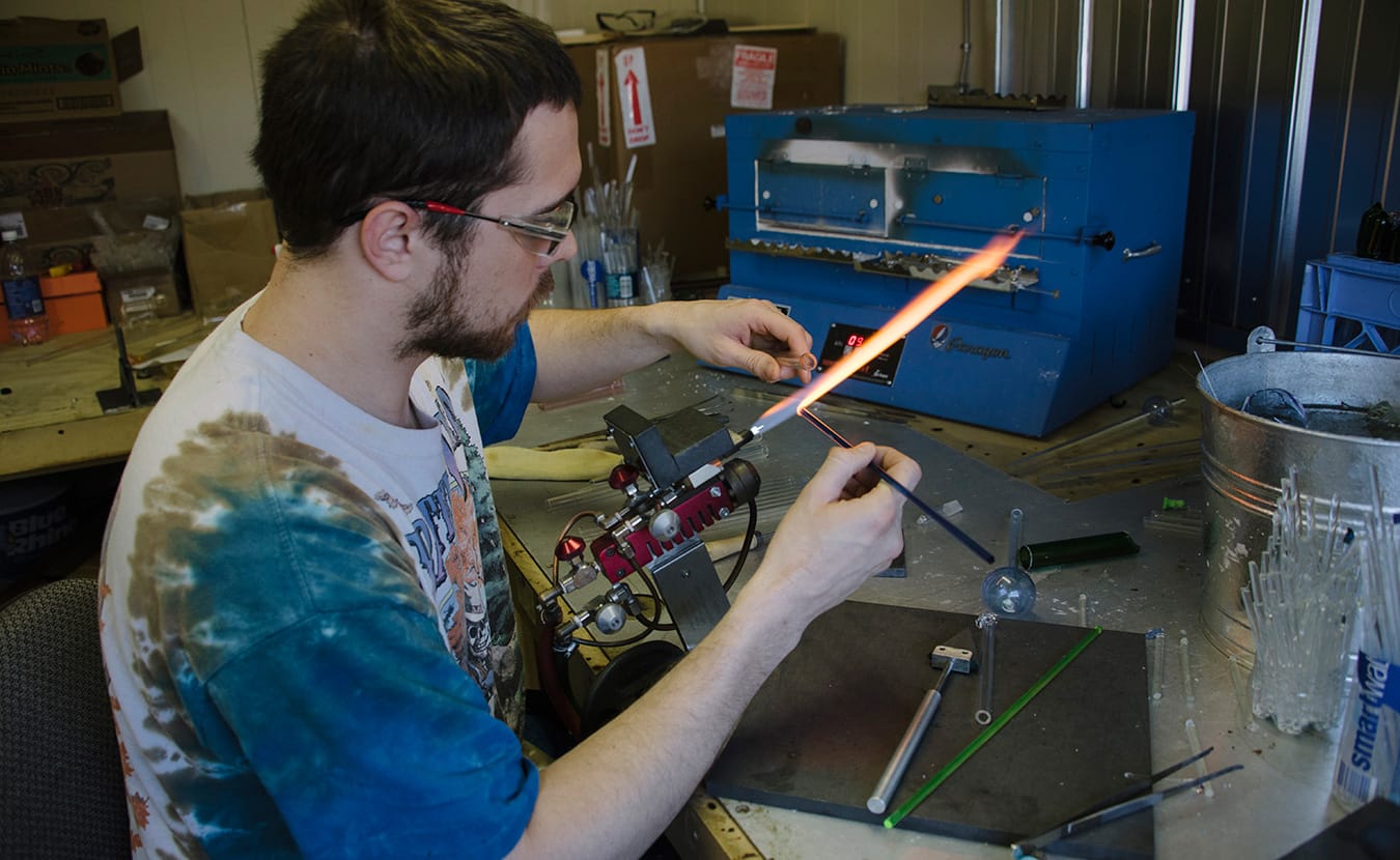 Max "Rowdy" Van Deneede, owner of Rowdy Glass Company, working in his studio. | Photo by Natasha Komoda