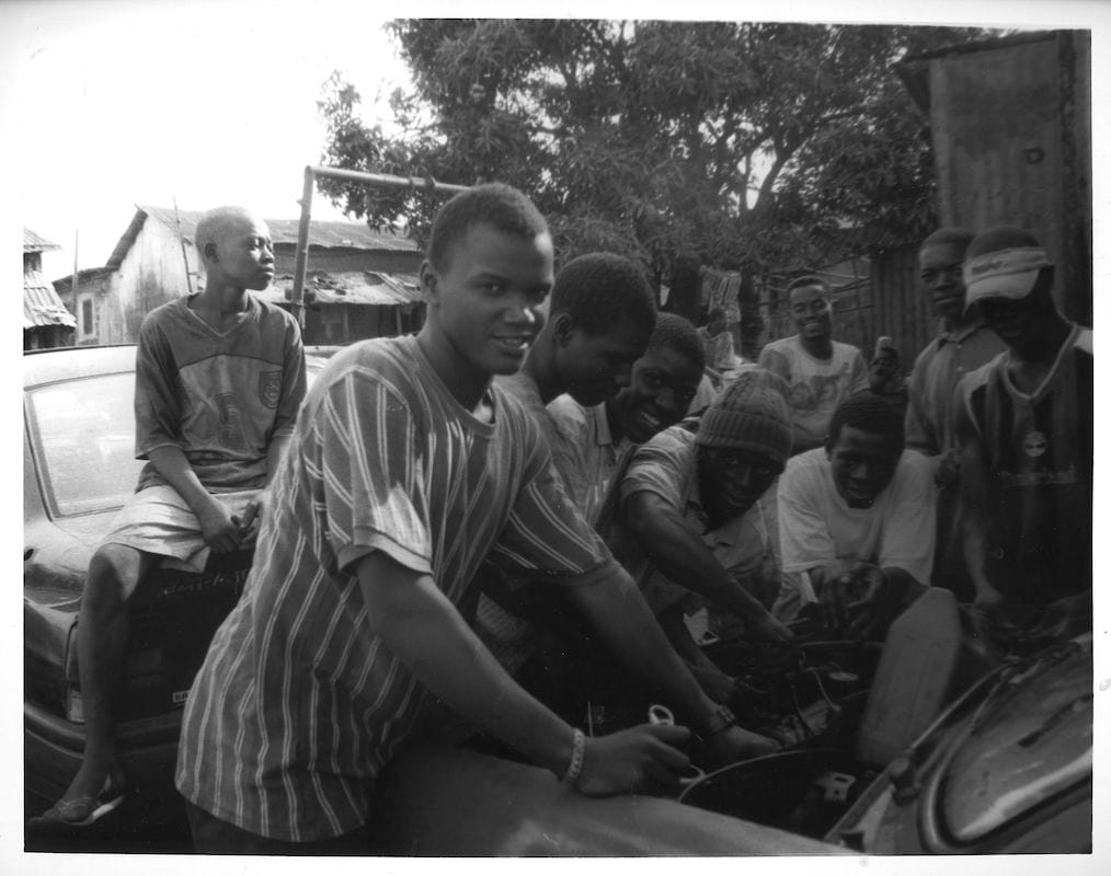 Le Mécanicien Automobile (The Mechanics), Conakry, Guinea, 2009, Gelatin Silver Print. Young men learn the art of being a mechanic in a small trade school.