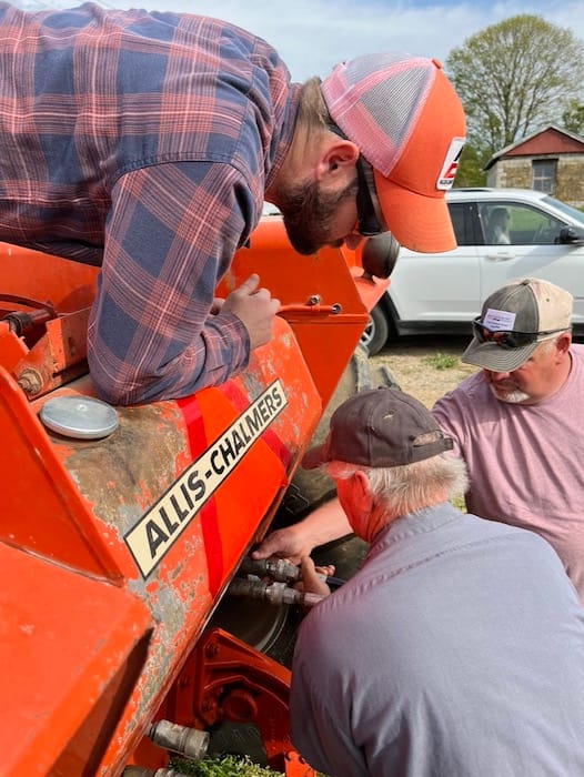 (clockwise from top) Zach Clark watches Kevin Zikes and Joel Clark attach hydraulic hoses to Zach's Allis-Chalmers during plow day.