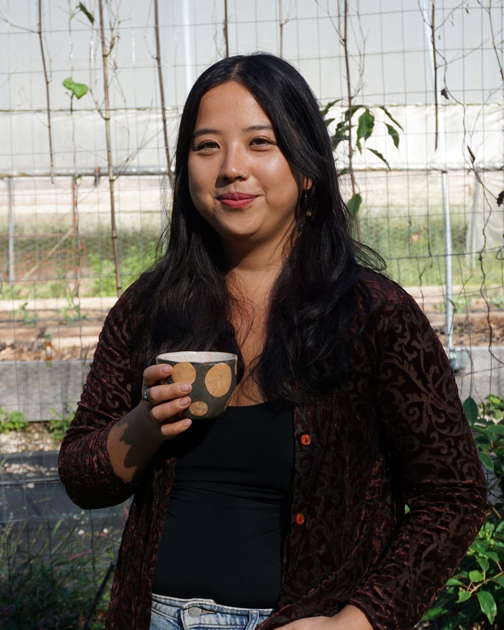 Ash Teng, owner of Blossom & the Bee Tea Co., enjoys a cup of mint tea on her farm in the Hoosier National Forest. | Photo by Anne Kibbler